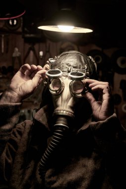 Solunum cihazı ve steampunk tarzı gözlüklü bir adam, palto giymiş, post tapokalipsis konsepti.