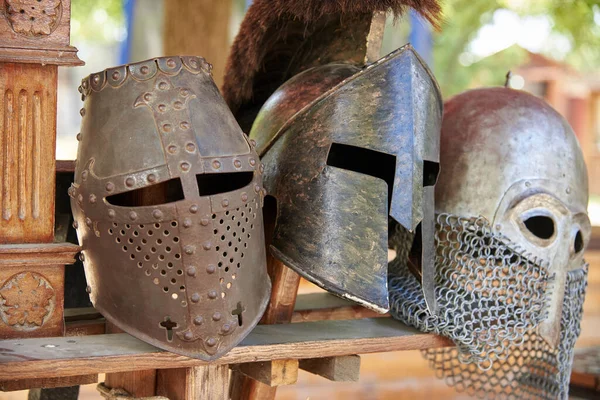 Three metal knight helmets for protection in battle.