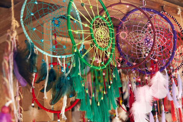 Handcrafted bright multi-colored dreamcatchers are posted for sale in the market.