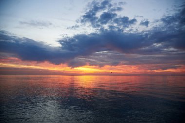 Şafak vakti güzel bulutlu gökyüzü, sakin deniz suyu, manzara.