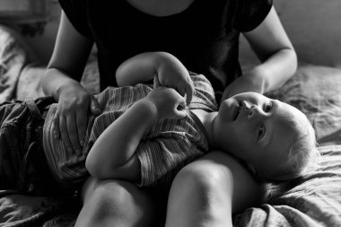 Anne ve küçük oğlu evde iyi vakit geçiriyorlar. Şefkat anı, siyah beyaz fotoğraf..