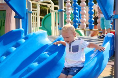 Kafkasyalı küçük bir çocuk oyun parkında kayıyor..