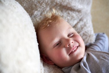 Yatağında uyanan üç yaşındaki komik sarışın bir çocuğun portresi..