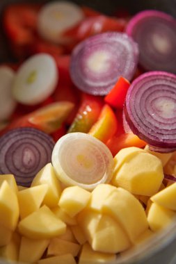Pişirmek için pişirilmiş çiğ sebzeler: Patates, soğan, yakın plan biber..