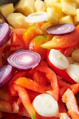 Pişirmek için pişirilmiş çiğ sebzeler: Patates, soğan, yakın plan biber..