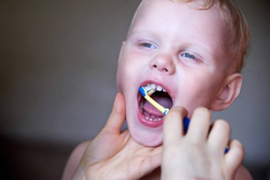 Annesi üç yaşındaki oğluna dişlerini fırçalamasını öğretiyor..