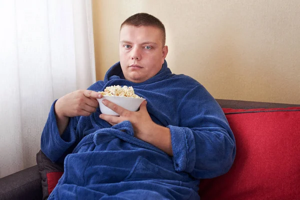Товстий Чоловік Халаті Їсть Попкорн Сидячи Дивані Ожиріння Неправильний Спосіб — стокове фото