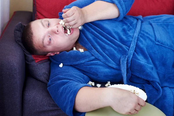 Uomo Grasso Accappatoio Mangiare Popcorn Mentre Sdraiato Sul Divano Obesità — Foto Stock