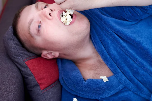 Hombre Gordo Una Bata Comiendo Palomitas Maíz Mientras Está Acostado — Foto de Stock