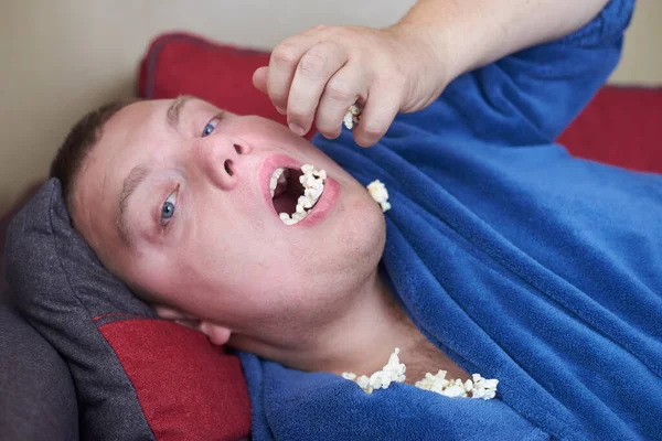 Hombre Gordo Una Bata Comiendo Palomitas Maíz Mientras Está Acostado — Foto de Stock