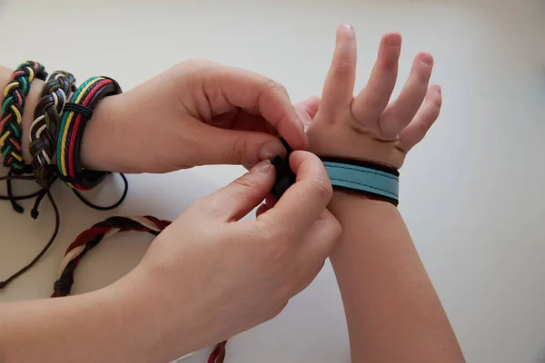 Vrouw Bindt Een Leren Armband Aan Arm Van Een Kind — Stockfoto