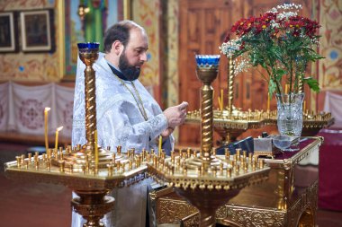 Ukrayna, Şostka, Vladimirskaya Kilisesi - 3 Mart 2019: Ortodoks Kilisesi 'ndeki beyaz elbiseli rahip ibadet ediyor
