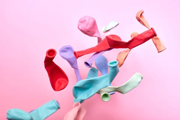 Vícebarevné Nenafukovací Balónky Hozené Vzduchu Růžovém Pozadí Kreativní Pozadí — Stock fotografie