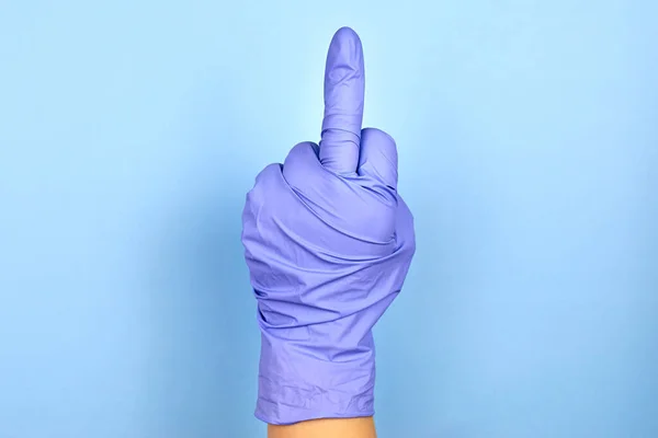 Egy Keze Egy Orvosi Kesztyűben Egy Középső Ujjmozdulatot Mutat Kék — Stock Fotó