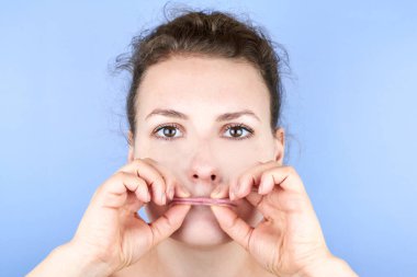 Yüz egzersizi yapan güzel bir kadın, yüz bakımı, kırışıklıklara karşı kendine masaj ve yaşlılık, cildin güzelliğine önem verir..