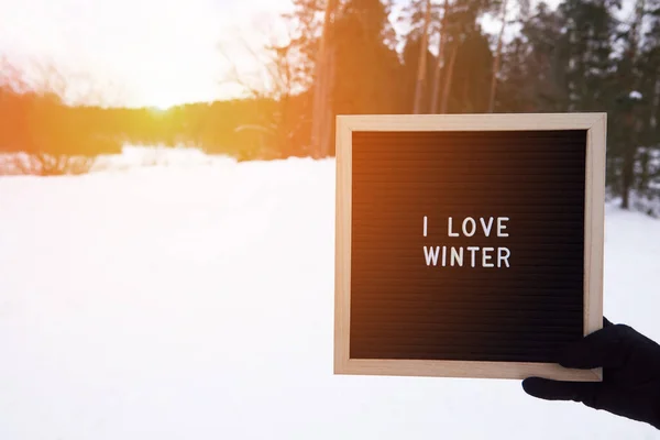 一个画框 上面有这样的题词 我喜欢冬天在一个戴着手套的女人手里 — 图库照片