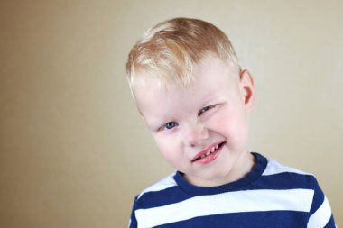 Gözü kapalı üç yaşında, beyaz, komik bir çocuğun portresi..