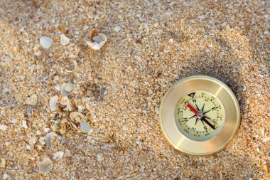 Pusula deniz kıyısındaki kumun üzerinde duruyor. Kopya alanı, yaz yolculuğu konsepti..