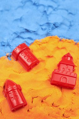 Plastik boncuklar parlak kinetik kumun üzerinde yatıyor, çocukların eğlencesi..