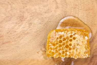 Ahşap bir arkaplanda bal tarağı, yakın plan, üst görünüm, boşluk kopyala.
