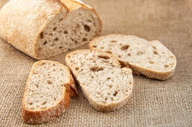 Çuval bezinde dilimlenmiş taze ekmek parçaları, yakın plan..