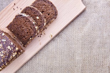 Çavdar ekmeği dilimlenmiş tam ayçiçeği tohumu, keten tohumu ve yulaf ezmesi tahtada, boşluk kopyala.