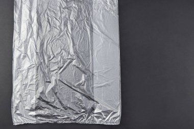 Koyu arka planda üç plastik torba, çevre kirliliği kavramı.