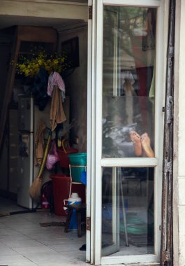 Pencerede ev ve insan bacakları
