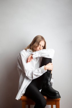 Stüdyoda sandalyede oturan sarışın kız.