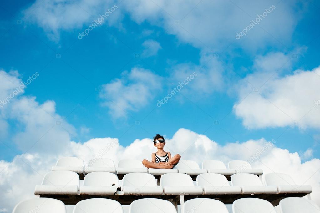 Boy sitting on stadium chair