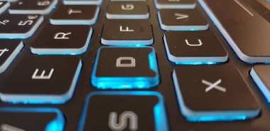 Anahtarı ve kalemi beyaz ve mor renkli bilgisayar klavyesi.