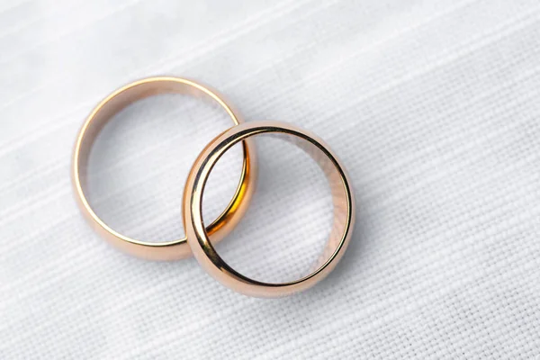 Two golden rings on white tablecloth Foto Stock