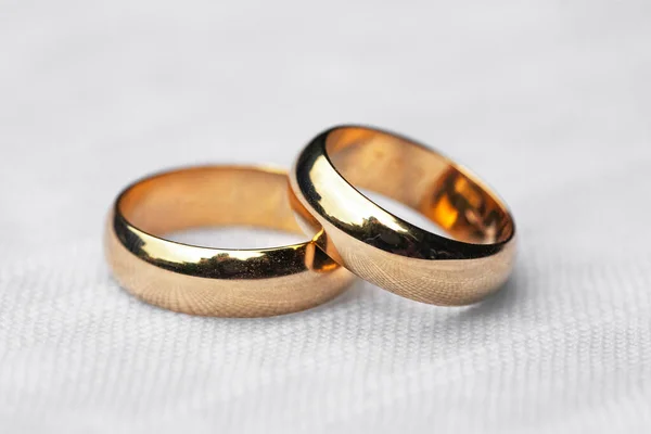Two wedding rings on white tablecloth — Stock Photo, Image