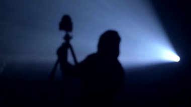 Nöbetçi tripodu olan bir fotoğrafçının silueti.