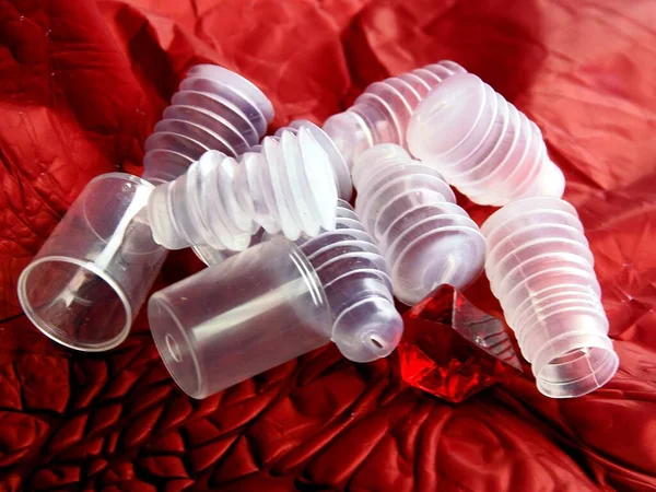 Kırmızı Kağıt Üzerindeki Plastik Nesneler Soyut Bileşim Olarak — Stok fotoğraf