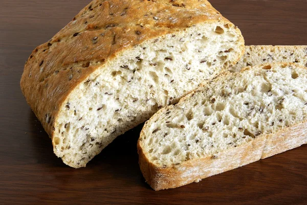 Pane e fette di pane con lino e semi di cumino — Foto Stock