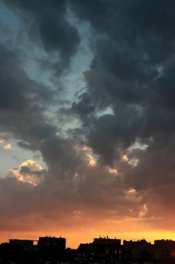 Renkli bulutları ve güneş ışığıyla resmedilmiş manzara