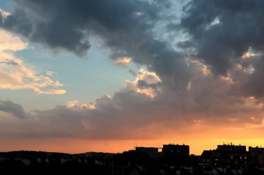 Renkli bulutları ve güneş ışığıyla resmedilmiş manzara