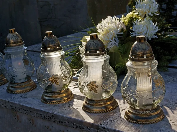 Burning candles on tomb in cemetery — Stock Photo, Image