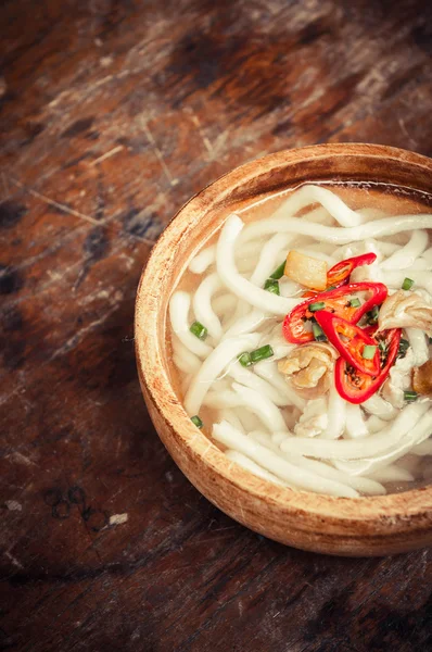 Close-up van udon noedels in houten kom op houten vloer — Stockfoto