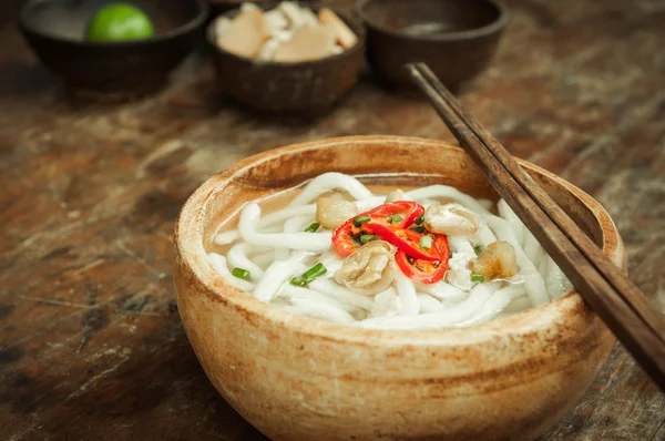 Close-up de macarrão udon em tigela de madeira no chão de madeira — Fotografia de Stock