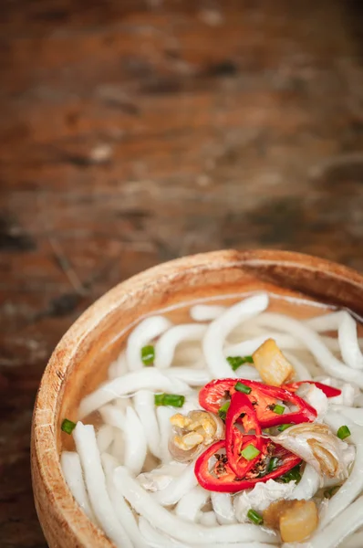 Close-up de macarrão udon em tigela de madeira no fundo do chão de madeira — Fotografia de Stock