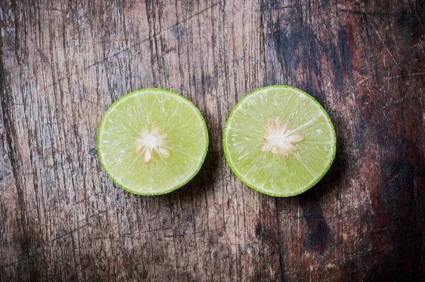 Limão verde corte no fundo de madeira — Fotografia de Stock