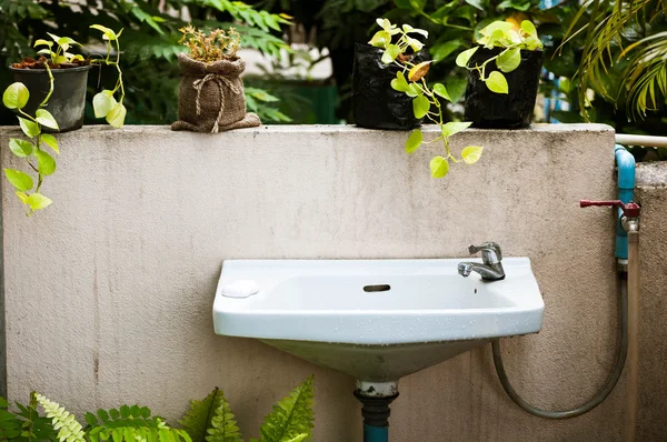 Vintage bahçe içinde lavabo ve grunge duvar — Stok fotoğraf