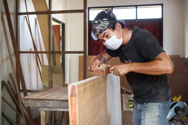 Carpenter man use planer making a wood door — Stock Photo, Image