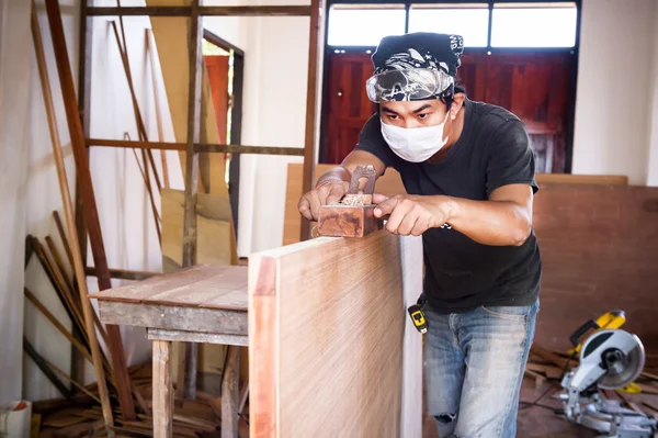 Carpintero hombre tomar una herramienta cepilladora con madera en el taller —  Fotos de Stock