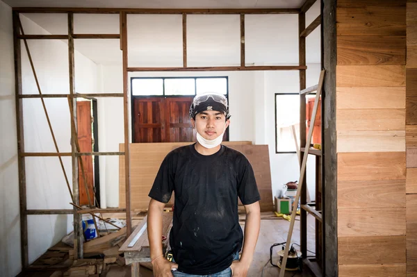Portret van de jonge mannelijke timmerman in workshop interieur — Stockfoto