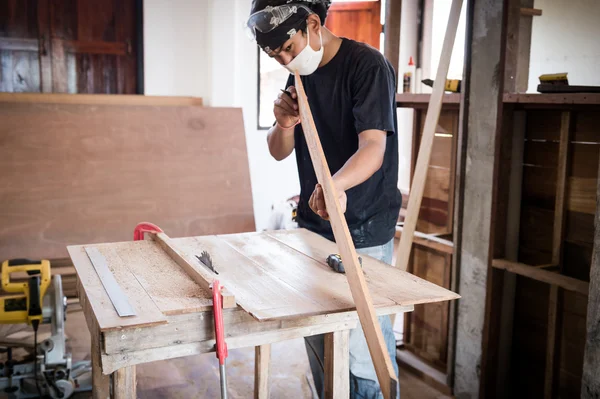 Jeune menuisier travaillant le bois en atelier — Photo