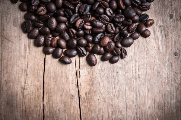 Granos de café sobre fondo de madera — Foto de Stock