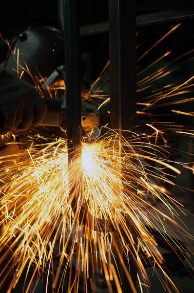 industrial working of grinding sparks with worker